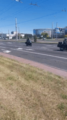 Motorcycles travel through sunny Brest streets during midday