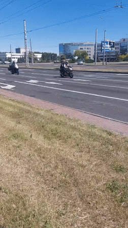 Motorcycles travel through sunny Brest streets during midday