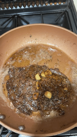 Steak and garlic searing in copper pan, South Staffordshire
