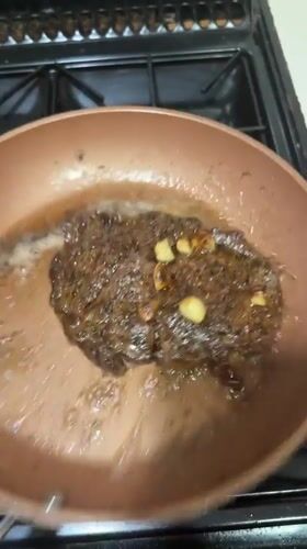 Steak and garlic searing in copper pan, South Staffordshire