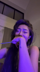 Woman recorded singing with makeshift microphone in bedroom setting