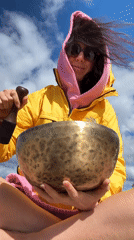 Brass singing bowl played outdoors under a cloudy sky