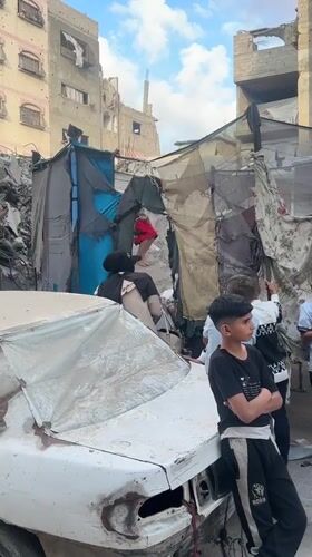Children play on trampoline amid damaged buildings in Gaza
