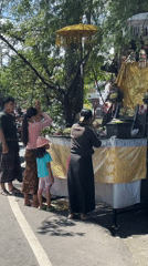 Family performs roadside religious ceremony in Denpasar Barat