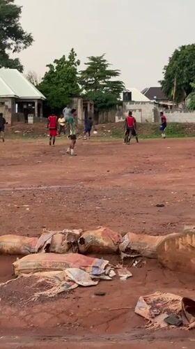 Community football match played on muddy field in Nigeria