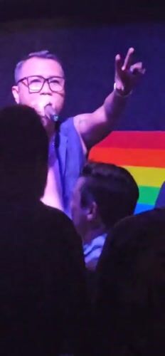 Live band performs at Denpasar venue with rainbow flag backdrop