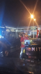 Vendors work a nighttime traffic queue at Melaya toll plaza