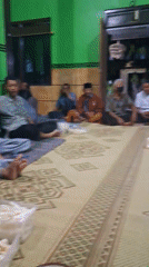 Communal floor meal in a green-walled room, Sidoharjo