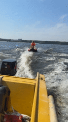 Tubing behind a yellow motorboat on a sunny Russian river