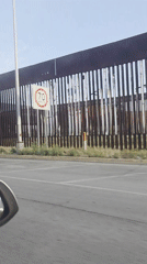 Vehicle recorded traveling alongside metal border wall in San Diego