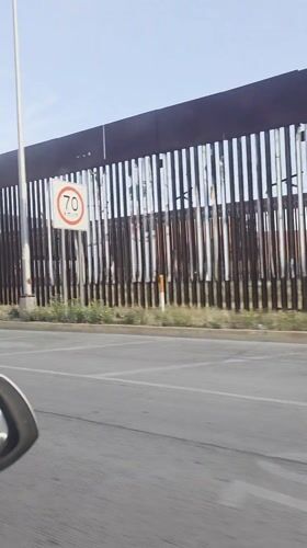 Vehicle recorded traveling alongside metal border wall in San Diego