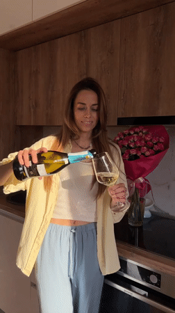Woman pours sparkling wine in kitchen, Bar Montenegro