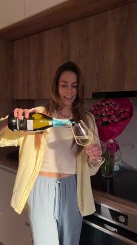 Woman pours sparkling wine in kitchen, Bar Montenegro
