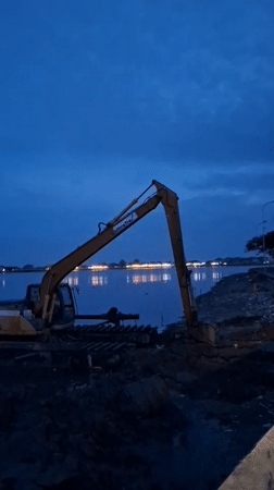 Excavator sits idle on waterfront in Lhokseumawe, Indonesia