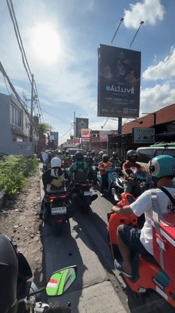 Morning rush hour traffic jams motorcycles in North Kuta