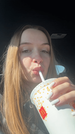 Woman drinks McDonald's beverage in car, Gornji Milanovac