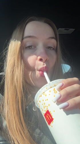Woman drinks McDonald's beverage in car, Gornji Milanovac