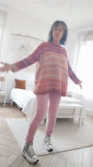 Woman shows off colorful striped sweater in Montélimar room