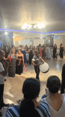 Circle dancing to live folk instrumentation in a formal indoor setting