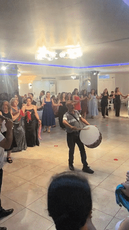 Circle dancing to live folk instrumentation in a formal indoor setting