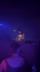 DJ performs in atmospheric Paris venue with colorful lighting