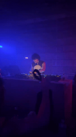 DJ performs in atmospheric Paris venue with colorful lighting