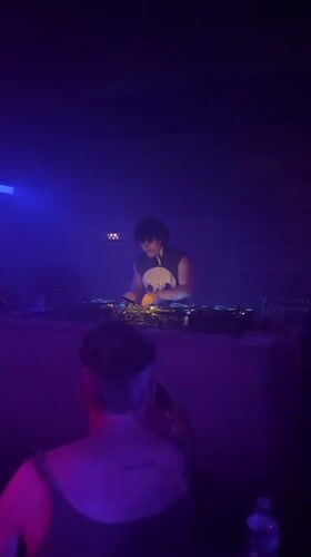DJ performs in atmospheric Paris venue with colorful lighting