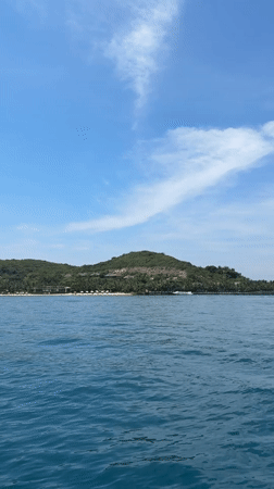 Island with beach facilities filmed from water near Nha Trang