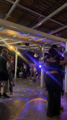 Nighttime dance party captured at thatched-roof bar in Thailand