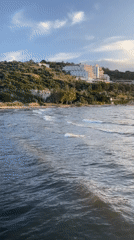 Coastal scene recorded in Selçuk, Turkey shows waves and beachgoers