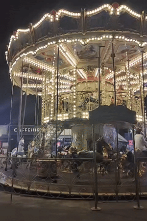 Summer fairground night in Odesa, rides running and crowds moving