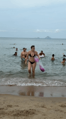 Busy morning at Nha Trang beach features swimmers, vendors, mermaid performers