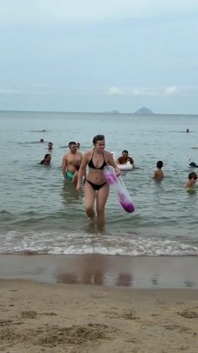 Busy morning at Nha Trang beach features swimmers, vendors, mermaid performers