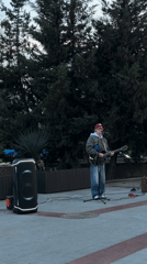 Street musician performs at illuminated park venue during evening