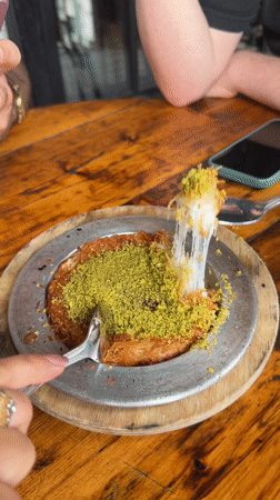Diners photograph Middle Eastern dessert kunafeh in New York restaurant
