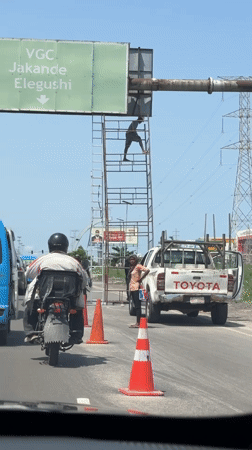 Worker maintains road sign in Igboefon, Nigeria