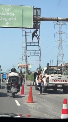 Worker maintains road sign in Igboefon, Nigeria