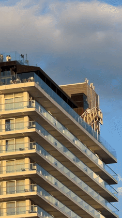 Glass-railed balconies on a cloudy New York evening