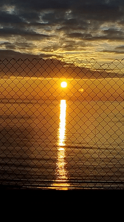 Sunrise captured through fence barriers in Varna, Bulgaria
