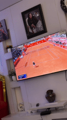 Jos resident watches varied TV programming in living room