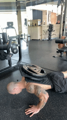 Man performs weighted push-ups at Pleven gym