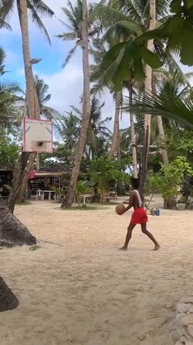 Beach basketball played on palm tree court in Philippines