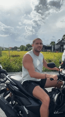 Man rides scooter through North Kuta wearing backpack
