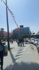 Turkish public square bustling with pedestrians amid Atatürk monuments