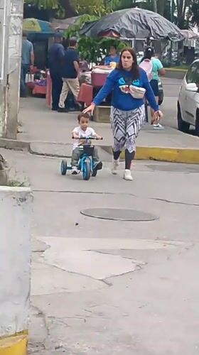 Evening street life in a dense Caracas hillside neighborhood