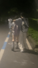 Nighttime pedestrians captured on Chongqing High-tech Zone pathway