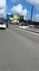 Motorcycle rider films sunny street scene in Dar es Salaam