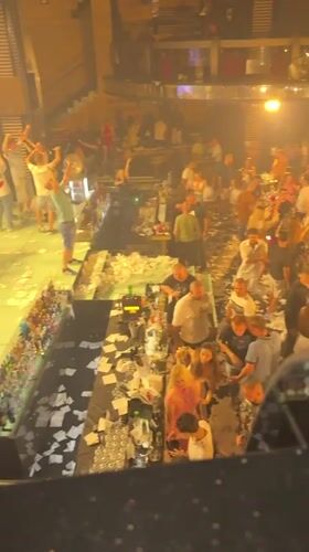 Crowded nightclub scene with scattered paper in Shumen