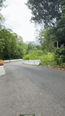 Motorcyclist recorded on wooded road in Chalong, Thailand