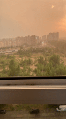 City skyline blanketed in orange haze at sunset
